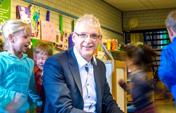 Adrie Groot tussen de spelende kinderen van groep 1/2 van de Paulusschool in Heiloo. Foto Erna Faust